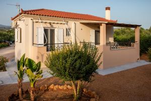 a small house with a balcony in front of it at Lagouvardos Beach Apartments in Marathopoli