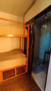 two bunk beds in a small room with a mirror at Eco Hostel & Suítes in São Miguel do Gostoso