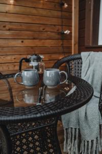 a table with two cups and a tea pot on it at Alejas apartamenti in Augšlīgatne