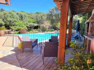 a patio with a table and chairs next to a pool at Casa Marcelli 5 in Porto-Vecchio
