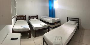Kleines Zimmer mit 3 Betten und einem Tisch in der Unterkunft Novo Hotel in Carolina