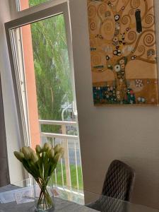 a vase of flowers on a table next to a window at AKK4 - Apartment MD Zentrum nähe Uni und Hbf in Magdeburg