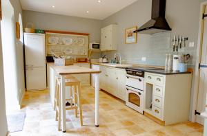 a kitchen with white appliances and a wooden table at Bragborough Hall Coach House in Braunston