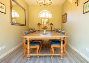 jadalnia z drewnianym stołem i krzesłami w obiekcie Bragborough Hall Coach House w mieście Braunston