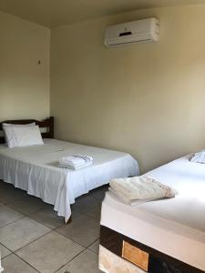 2 Betten in einem Zimmer mit Klimaanlage an der Wand in der Unterkunft Novo Hotel in Carolina