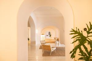 an archway leads into a living room with a table and chairs at Miramare Sea Resort & Spa in Ischia