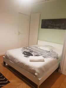 a bedroom with a bed with two towels on it at Chambre Ricardo in Orsay