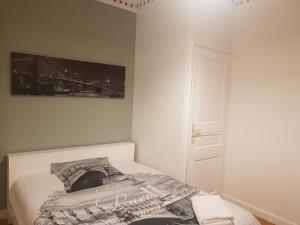 a bedroom with a bed with a picture on the wall at Chambre Ricardo in Orsay