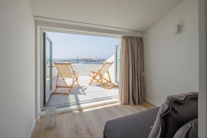 sala de estar con vistas a un balcón con sillas en Lapa 84 - seafront house en Póvoa de Varzim