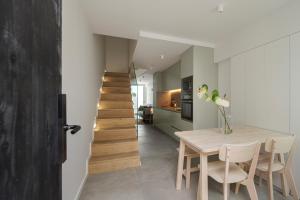 a kitchen and dining room with a table and a staircase at Lapa 84 - seafront house in Póvoa de Varzim