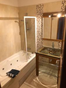 a bathroom with a tub and a shower and a sink at Appartement tout confort - Belle vue sur le Cambre d'Aze in Bolquere Pyrenees 2000