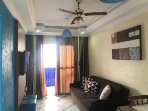 Una sala de estar con un sofá y un ventilador de techo. en Apto Azul Oceano, en Mongaguá 16 fotos más