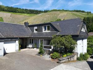 a house with a vineyard in the background at Ferienwohnung Heiming in Saarburg