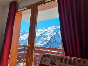 a view of a snow covered mountain through a window at Chalet JL et DS , Pied des pistes, Valmeinier 1800, 10 pers. in Valmeinier