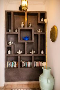 een boekenplank met een vaas in een kamer bij Riad Alnadine in Marrakesh