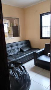 - un salon avec un canapé en cuir noir et une fenêtre dans l'établissement Apartamento com1 vaga na garagem FREE ! PRAIA GRANDE, à São Paulo