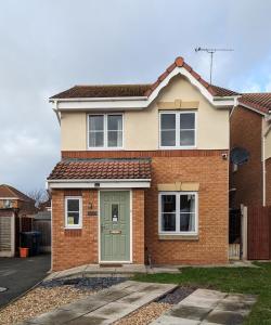 a brick house with a green door at 3 bedroom detached by the sea in Prestatyn