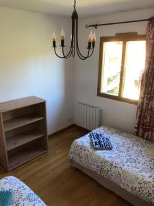 a bedroom with two beds and a chandelier at Appartement tout confort - Belle vue sur le Cambre d'Aze in Bolquere Pyrenees 2000