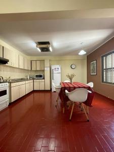 a large kitchen with a table and a white refrigerator at Departamento Familiar Amplio y Luminoso en Rafaela in Rafaela