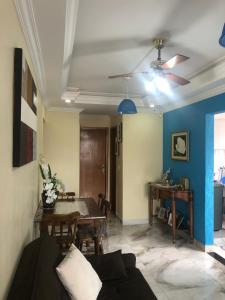 Una sala de estar con una mesa y un ventilador de techo. en Apto Azul Oceano, en Mongaguá