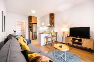 a living room with a couch and a tv at Mokotów Passion Apartment in Warsaw