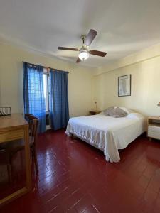 1 dormitorio con 1 cama y ventilador de techo en Departamento Familiar Amplio y Luminoso en Rafaela en Rafaela