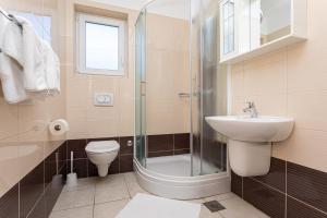 a bathroom with a shower and a toilet and a sink at Apartments Crnekovic Jasna in Baška