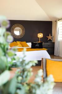 een slaapkamer met een bed met gele kussens en een spiegel bij Karibuni Boutique Hotel in Cul de Sac