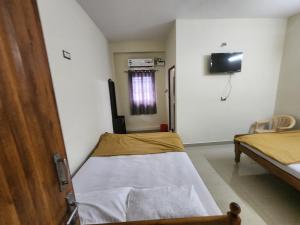 Un pat sau paturi într-o cameră la Raja Rani Mahal Ac-Rooms