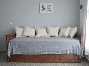 1 dormitorio con 1 cama con almohadas blancas en Cholito 2 en Alta Gracia