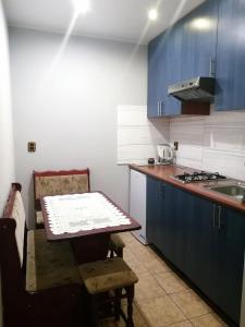 a kitchen with blue cabinets and a table and a sink at Pod Modrzewiem in Pogorzelce