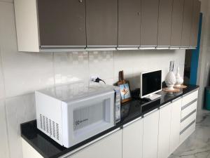 cocina con microondas y encimera en Apto Azul Oceano, en Mongaguá