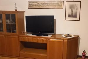 uma televisão em cima de um centro de entretenimento de madeira em Casa vacanze Donna Michela em Ponzano Vêneto