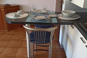 um balcão de cozinha com uma mesa com pratos e copos em Casa vacanze Donna Michela em Ponzano Vêneto