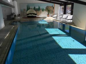 a swimming pool with blue water in a house at Staufenresidenz in Oberstaufen