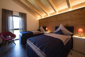 ein Hotelzimmer mit einem Bett und einem Stuhl in der Unterkunft Châlets de la Liberté in Oberstaufen