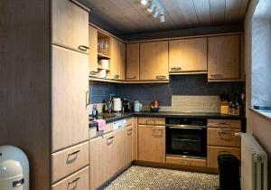 uma cozinha com armários de madeira e um forno em Säntisblick em Oberstaufen