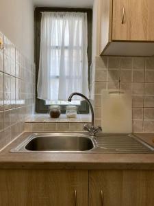 a sink in a kitchen with a window and a sink at Feidiou 1, vol I in Aegina Town