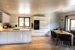 a kitchen with white cabinets and a table with chairs at Himmelseck in Oberstaufen