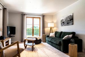 上斯陶芬的住宿－Himmelseck，客厅配有绿色沙发和电视