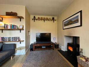 a living room with a couch and a tv and a fireplace at Immaculate 3 Bedroom House in Blair Atholl in Blair Atholl