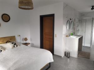 - une chambre blanche avec un lit et un lavabo dans l'établissement Gîte Le Framboisier V de la distillerie Bio Spirit Belgium, à Neufchâteau
