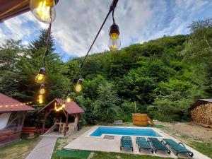 a group of lights hanging over a swimming pool at Cabana Lăcrămioara in Dejani