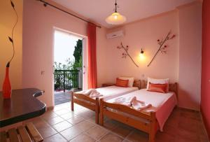 a bedroom with two beds and a balcony at Apartments Corfu Sun Sea Side in Benitses