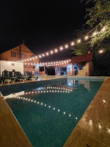 a swimming pool at night with lights above it at Cabana Lăcrămioara in Dejani