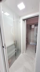 uma casa de banho com uma cabina de duche ao nível do chão e uma porta de vidro em Fiera Milano City Apartment em Milão