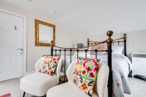 a bedroom with a bed and two chairs at The Mews - 1BR Studio in Jericho near City Centre in Oxford