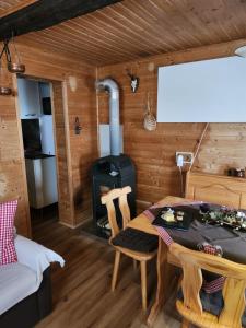 Habitación con mesa y estufa de leña. en Urige Waldbienenhütte, en Diex