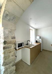 a kitchen with a sink and a microwave at le petit chalus grand gite in Forcalquier +7 photos