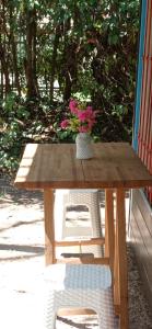 una mesa de madera con un jarrón de flores. en Cabañas del Pilar en Pilar